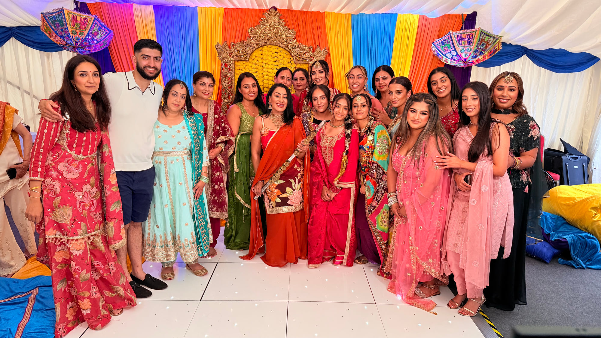 Reena Kaur with guests in colourful Punjabi outfits at a Sangeet in a decorated marquee